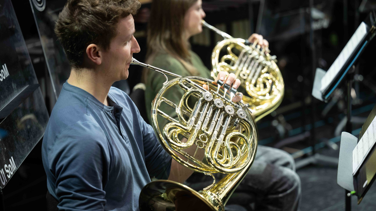 Close up photo of man playing the French Horn